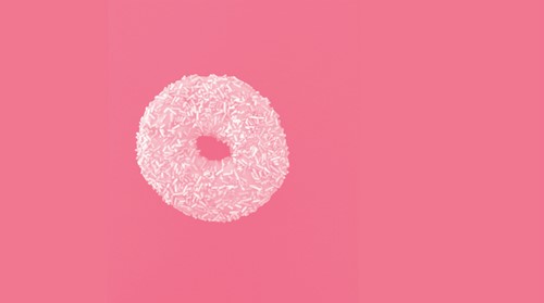 a sprinkle donut of a pink background