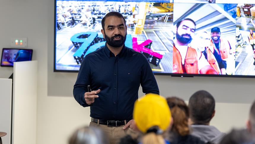 a person talking toa. room of people with a presentation