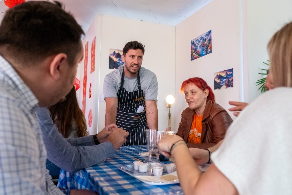 Student in apron talking to peers