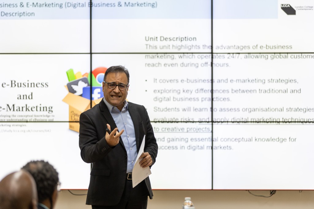 Man presenting with screen behind him.