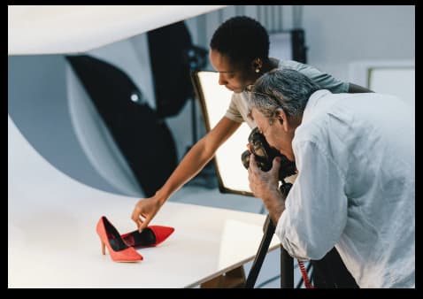 a person taking picture of red heels