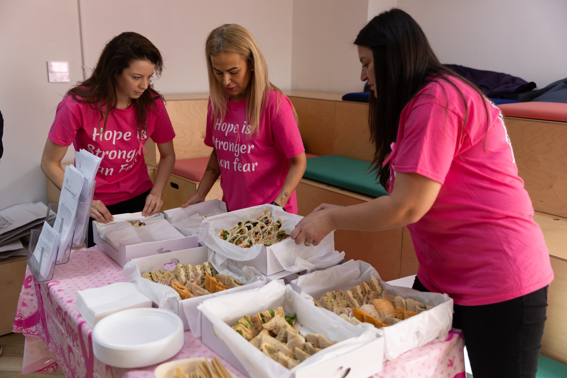 Hospitality students serving food at an event in pink shirts
