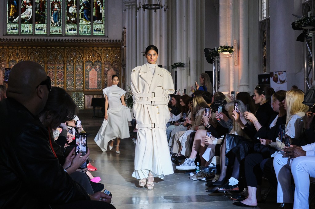Model on catwalk in a church in a white outfit