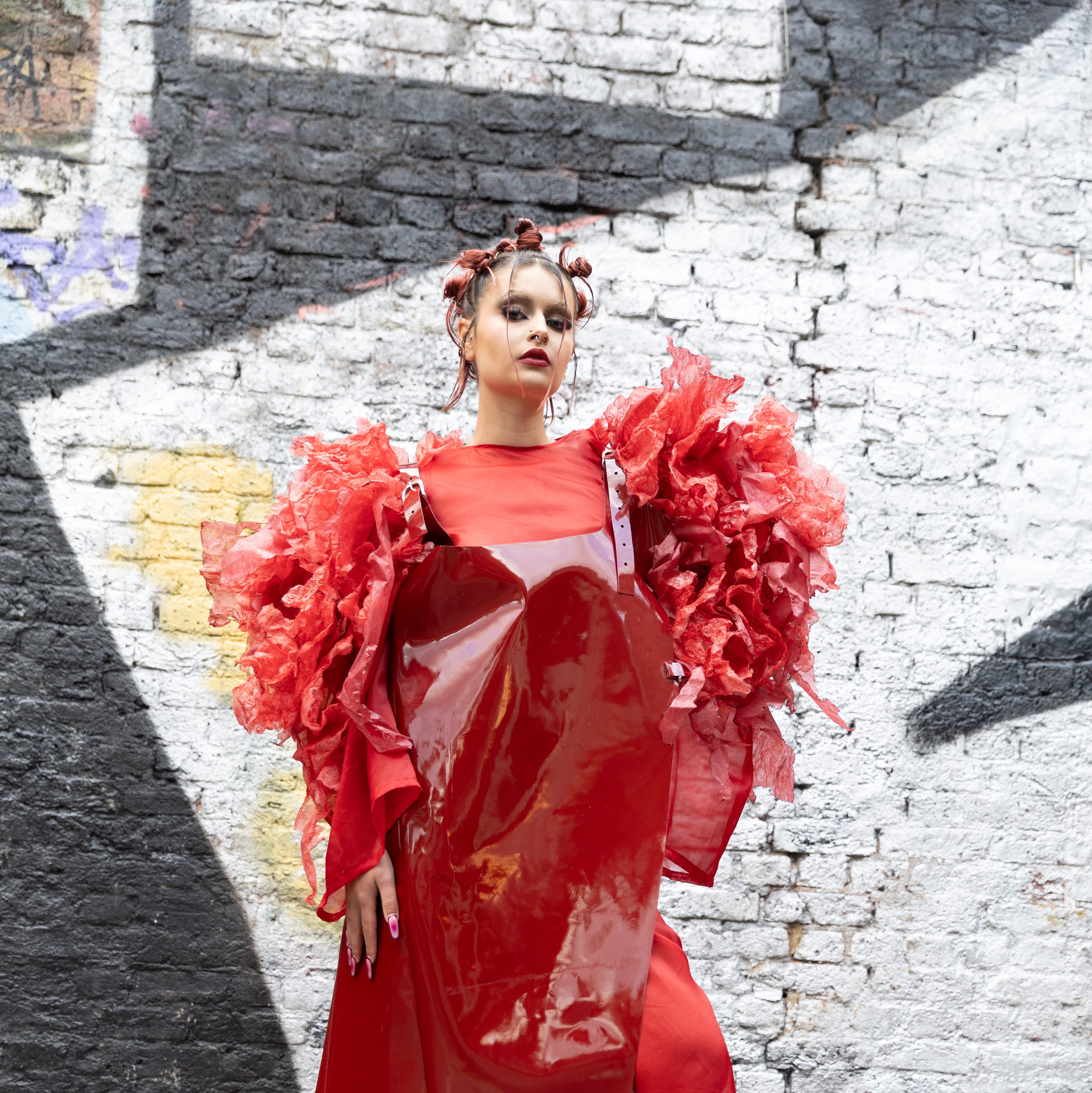 Model in red outfit on the street posing for fashion image