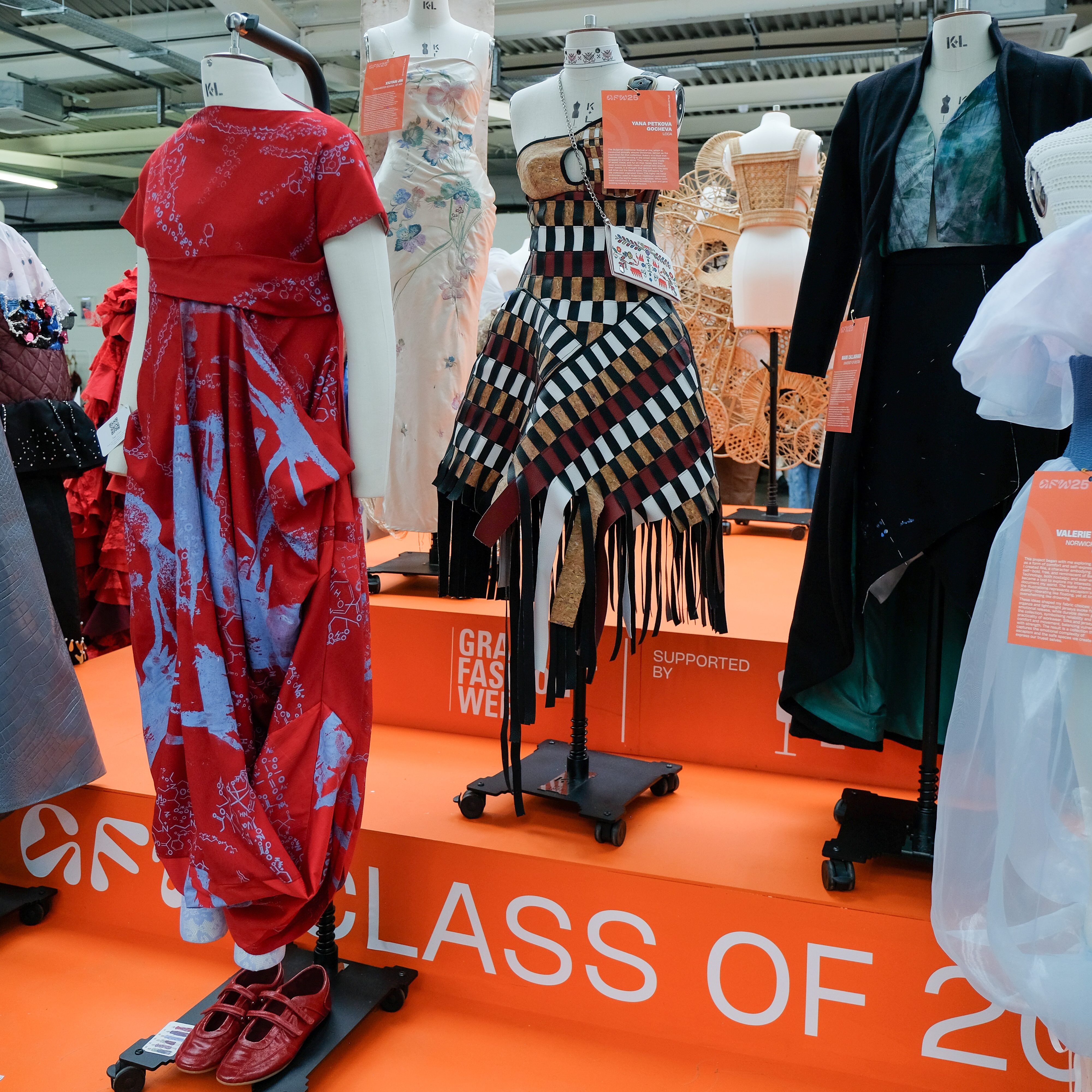 Various colourful garments on an exhibition podium 
