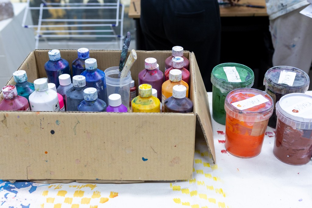 a box full of bottles of different paints