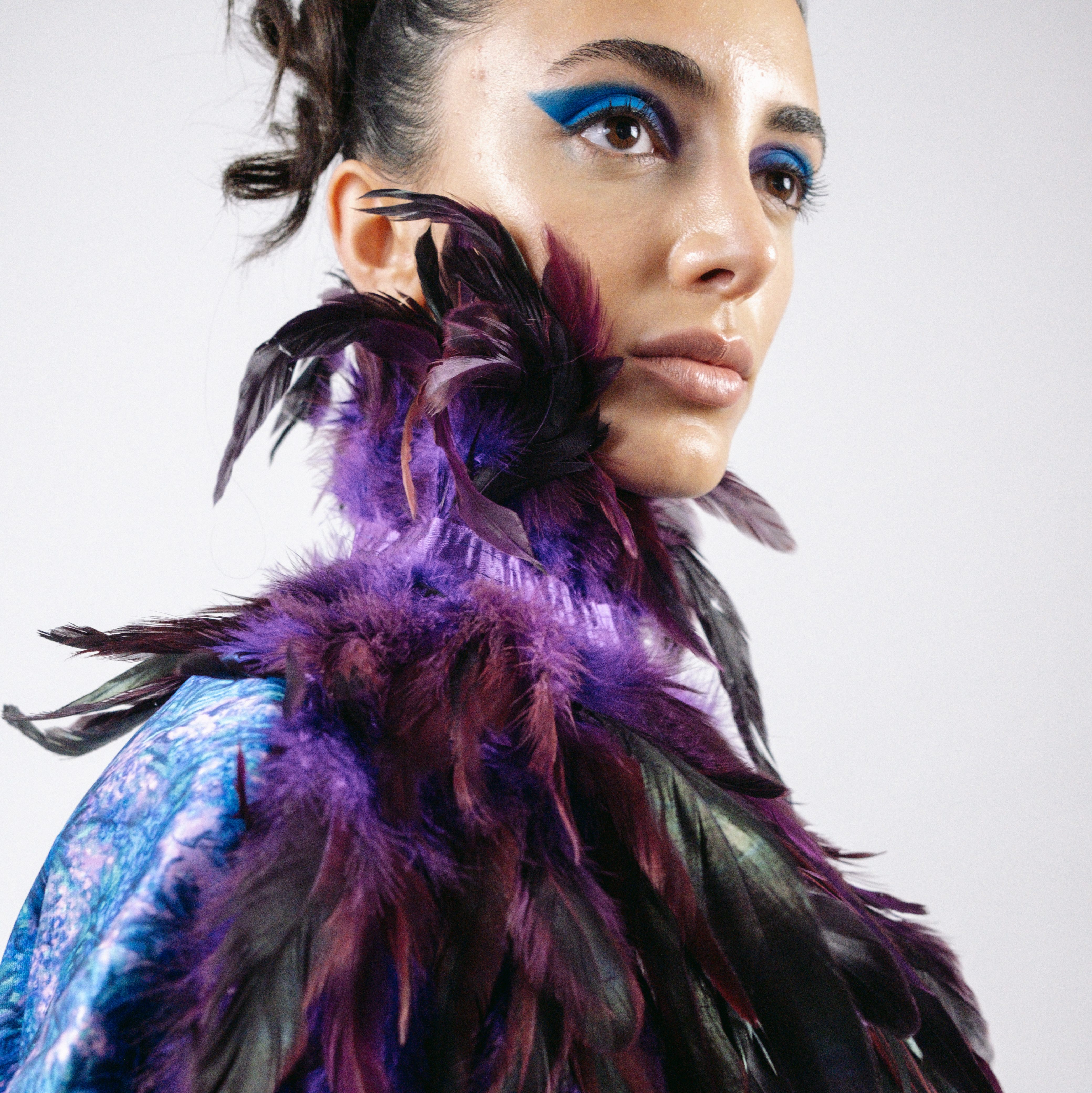 Female model in feather garment posing for editorial shot