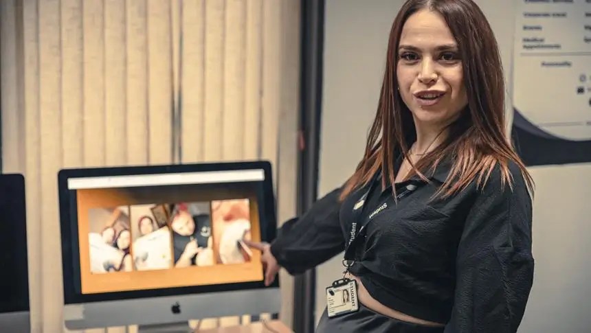 a girl in a black top point at a screen