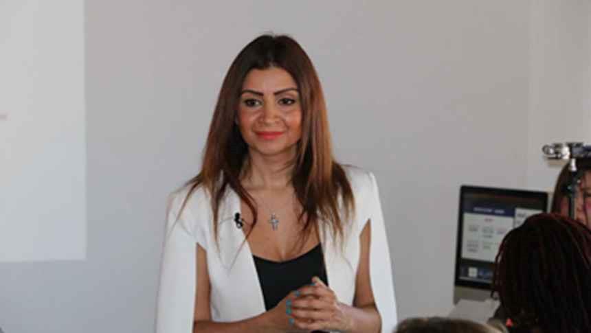 A women in white blazer smiling