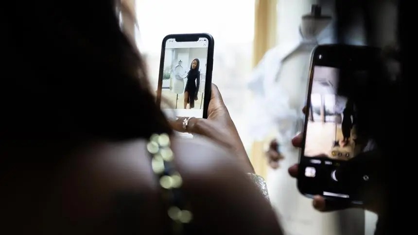 a person talking a picture of someone next to a mannequin