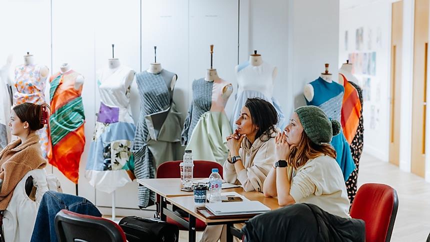 2 people surrounded by mannequins