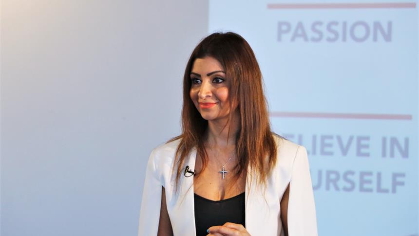 A women in a white blazer smiling