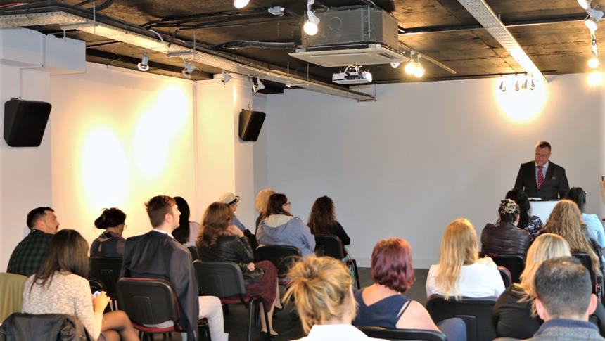 A man presenting to a room full of students