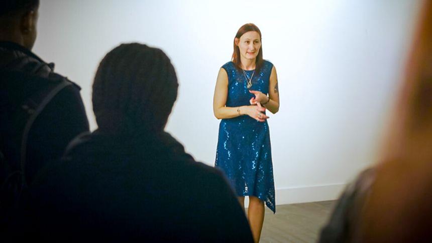 A person in a blue dress talking