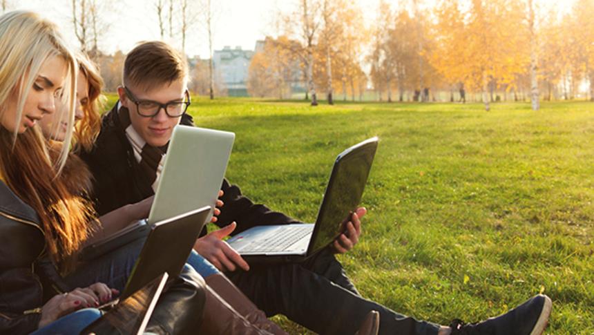 3 people looking at laptops