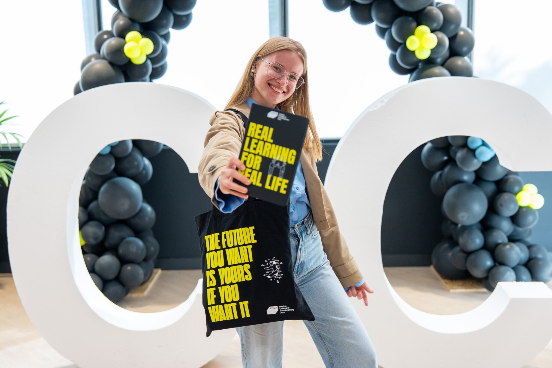 a person holding a notepad and a totebag