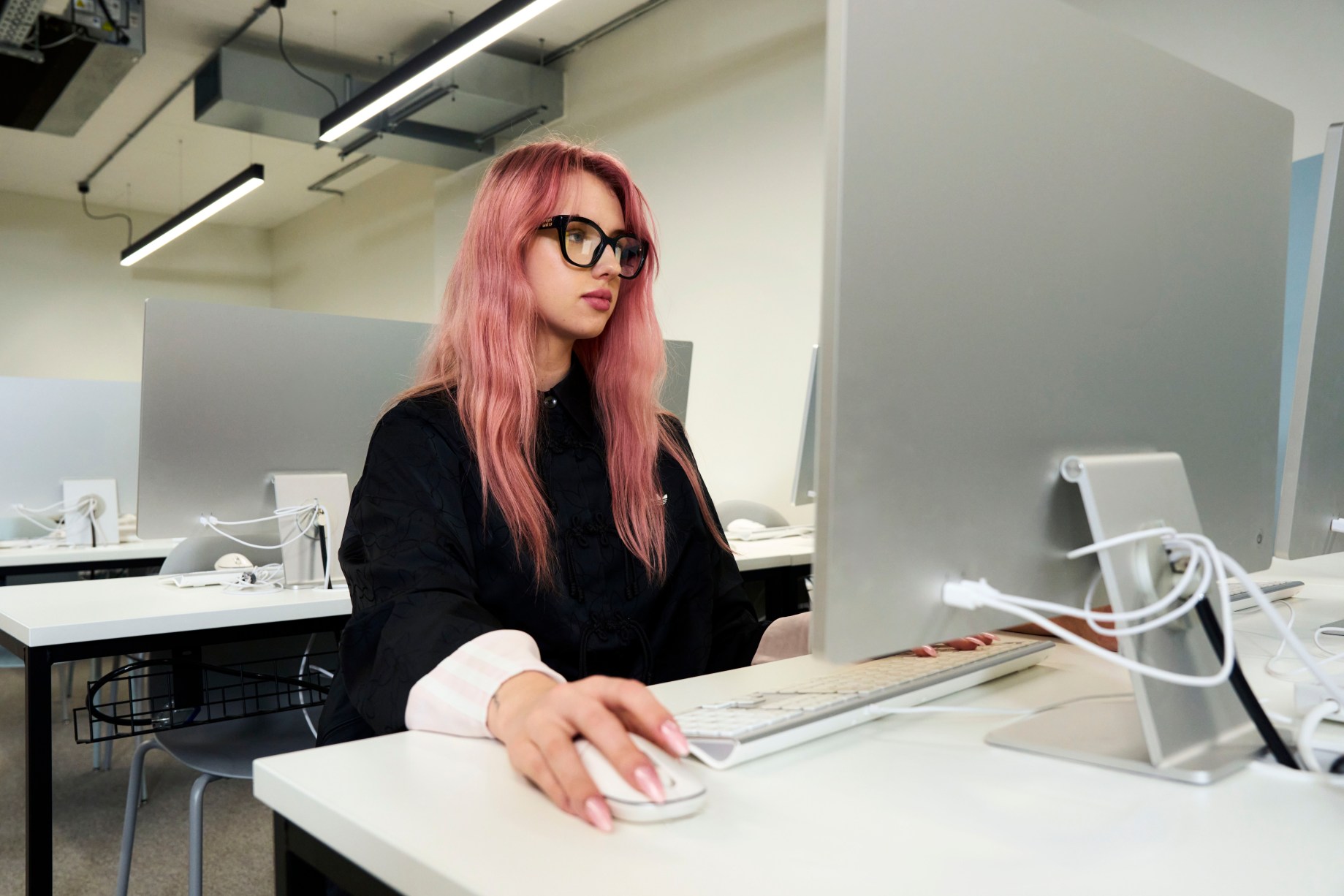 girl with glasses on a computer in a classroom